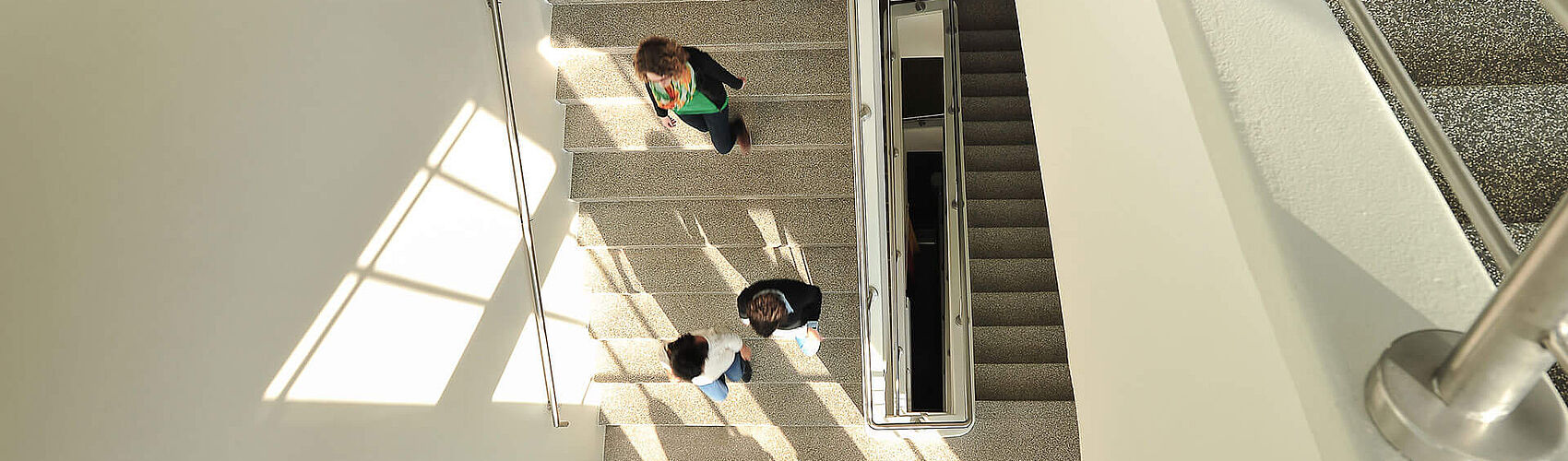 Studierende im Treppenhaus des Stadtgebäudes