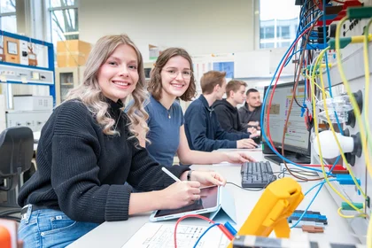 Zwei Studentinnen sitzen im Vordergrund an Computern, im Hintergrund weitere Studierende – Szene aus dem Hochschulalltag der TH Bingen.