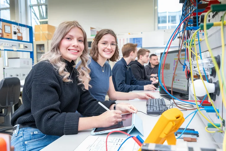 Zwei Studentinnen sitzen im Vordergrund an Computern, im Hintergrund weitere Studierende – Szene aus dem Hochschulalltag der TH Bingen.