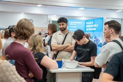 Studierende auf dem Industrietag 2025 im Beratungsgespräch am Stand.