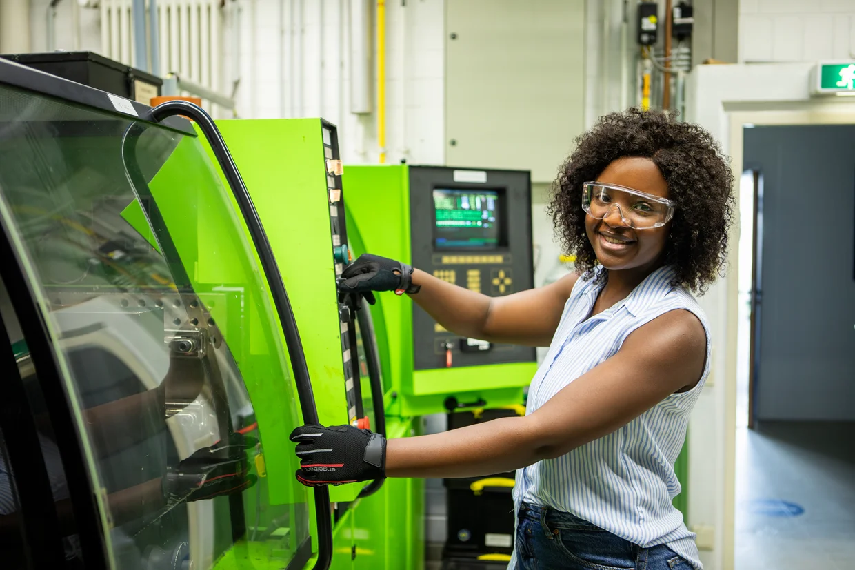 Das Bild zeigt eine Studentin im Labor an einem Gerät