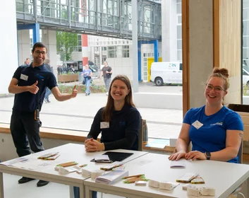 Drei lachende Helfer:innen der Umweltmesse