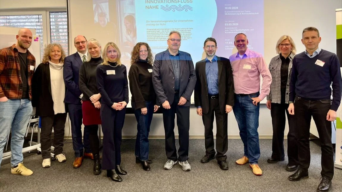 Gruppe Personen in einer Reihe vor Präsentationsbildschirm