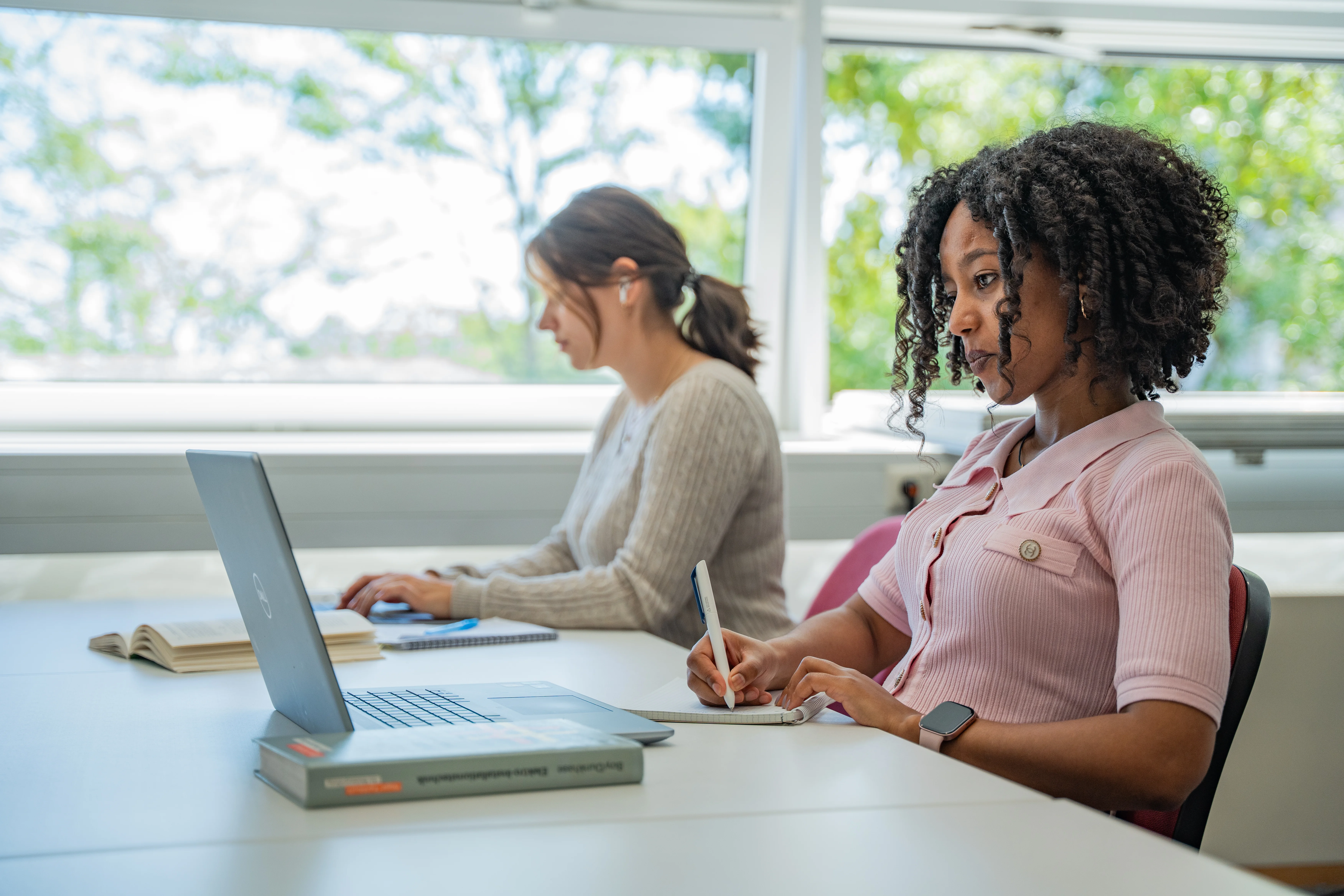 Zwei Studentinnen lernen in der Bibliothek.