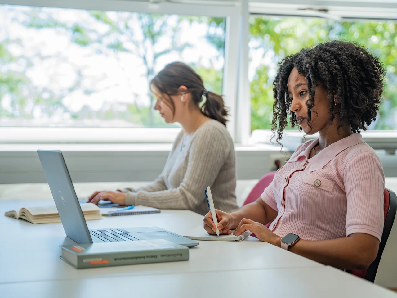 Zwei Studentinnen lernen in der Bibliothek.