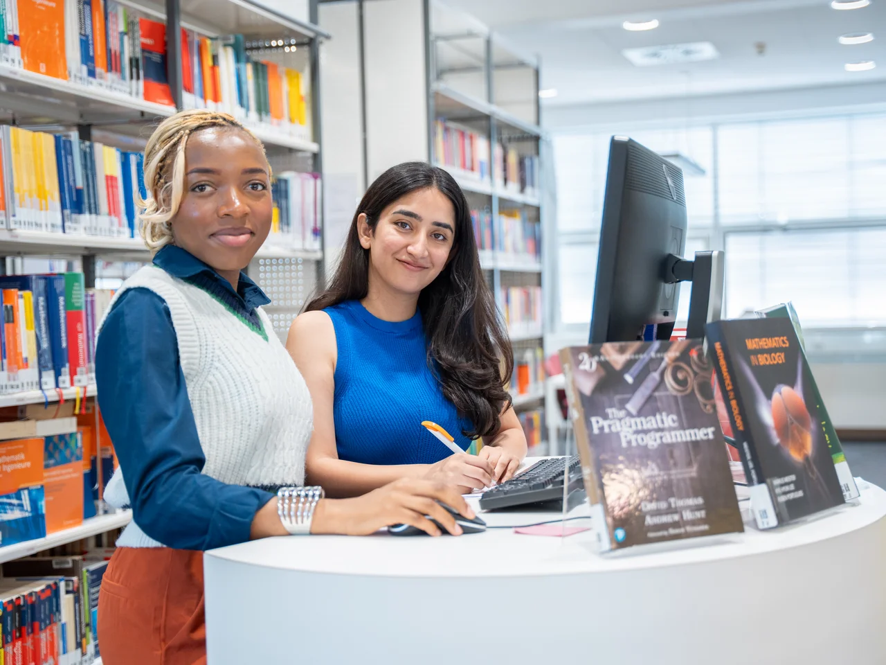 Zwei Studentinnen bei der Literaturrecherche in der Bibliothek.