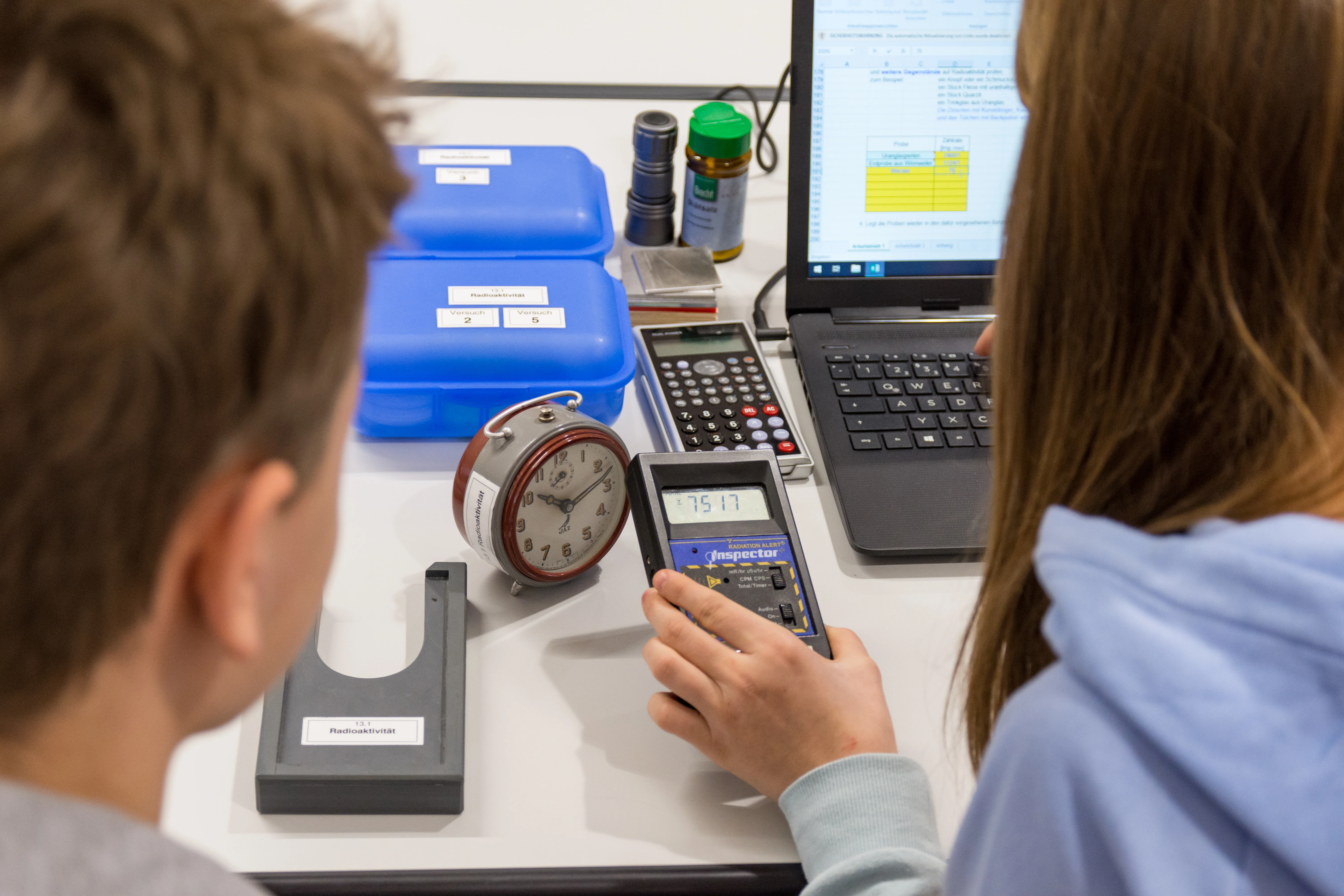 Auf dem sind zwei Jugendliche zu sehen, die ein Experiment im Rahmen des Energieparcours durchführen.