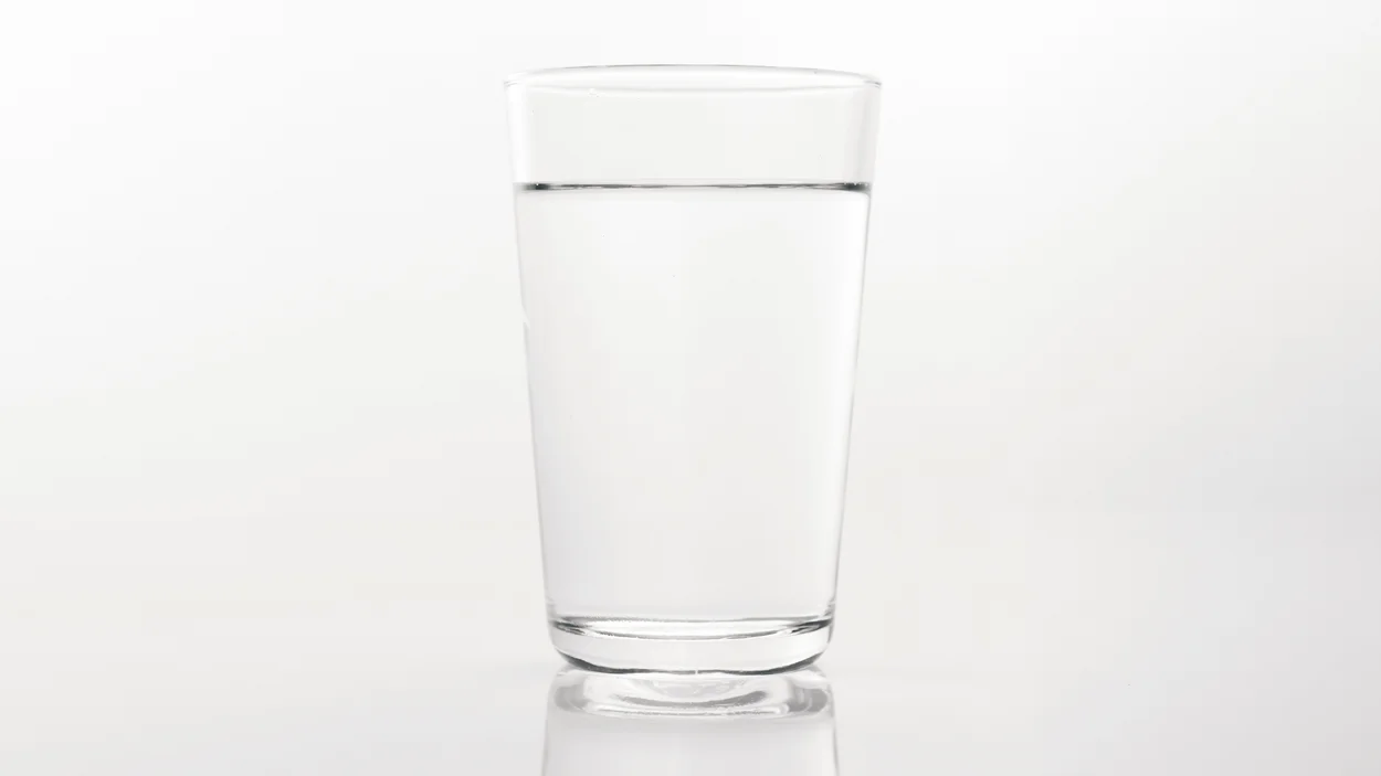 Ein Glas Wasser vor hellgrauem Hintergrund