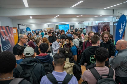 Studierende auf dem Industrietag 2025 im Beratungsgespräch am Stand.