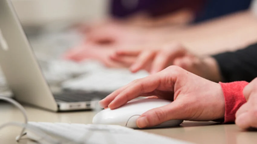 Auf dem Bild ist eine Hand zu sehen auf einer Computermaus