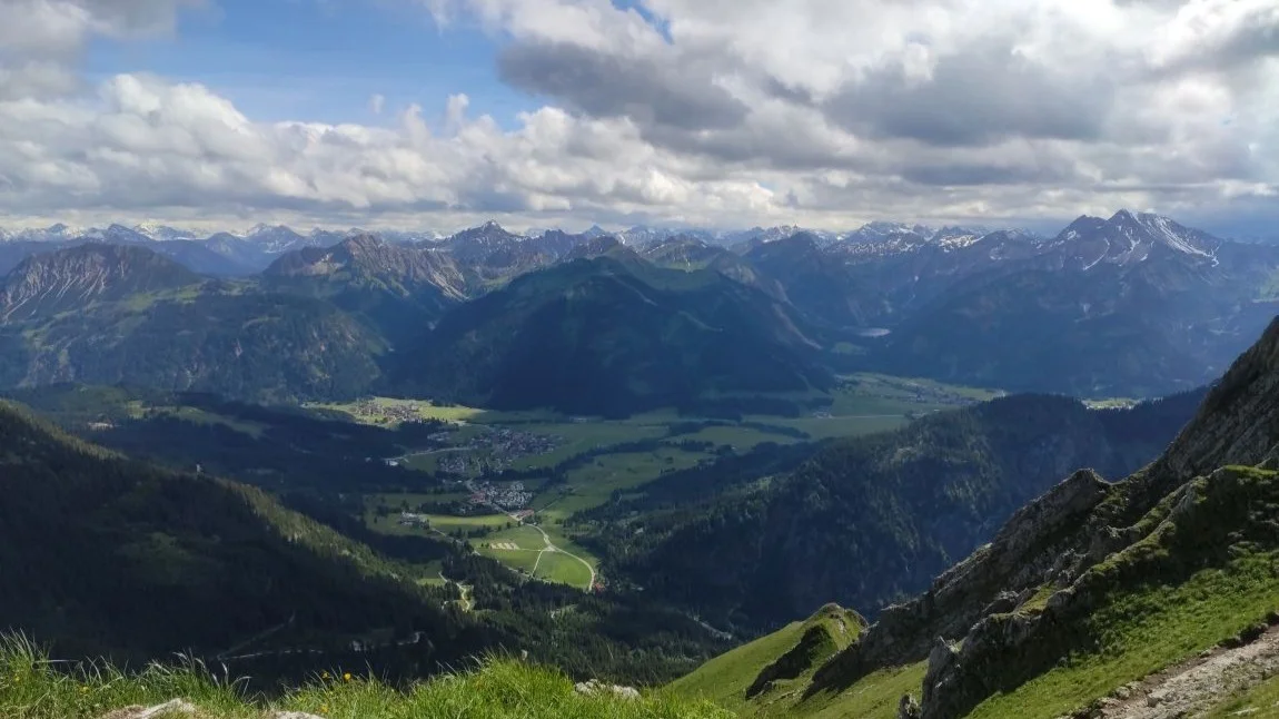 Blick vom Gipfel hinunter ins grüne Tal