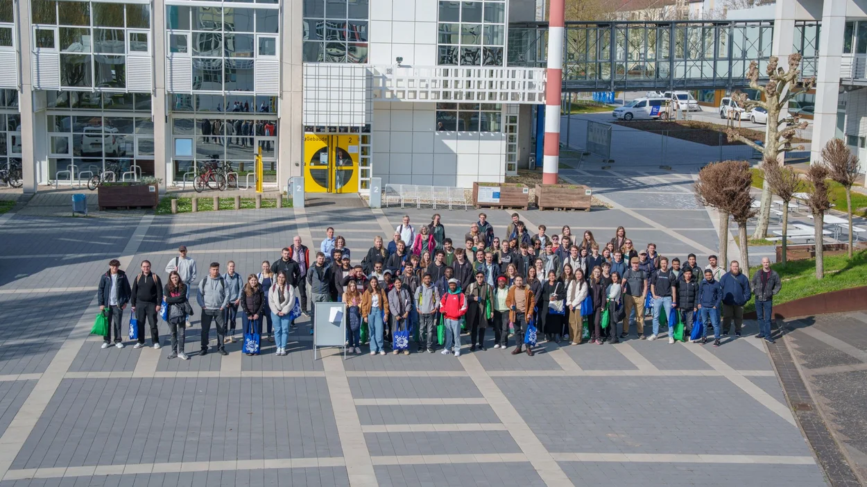 Die Erstsemesterstudierenden versammeln sich zum gemeinsamen Foto im Innenhof des Campus.