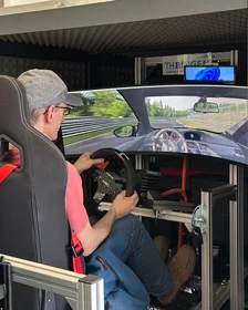 Ein junger Mann fährt eine Strecke im Fahrsimulator