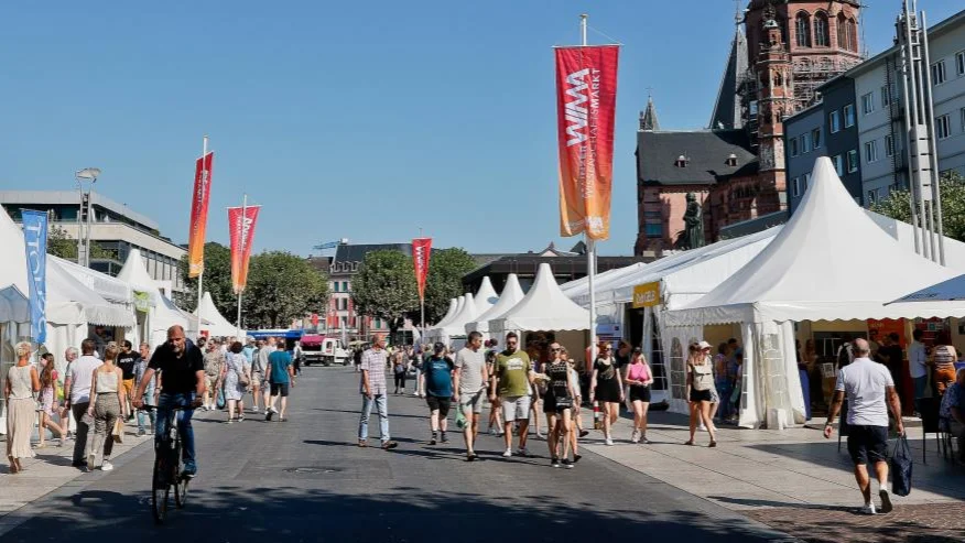 Straße in Mainz mit weißen Pavillons links und rechts und schlendernden Menschen