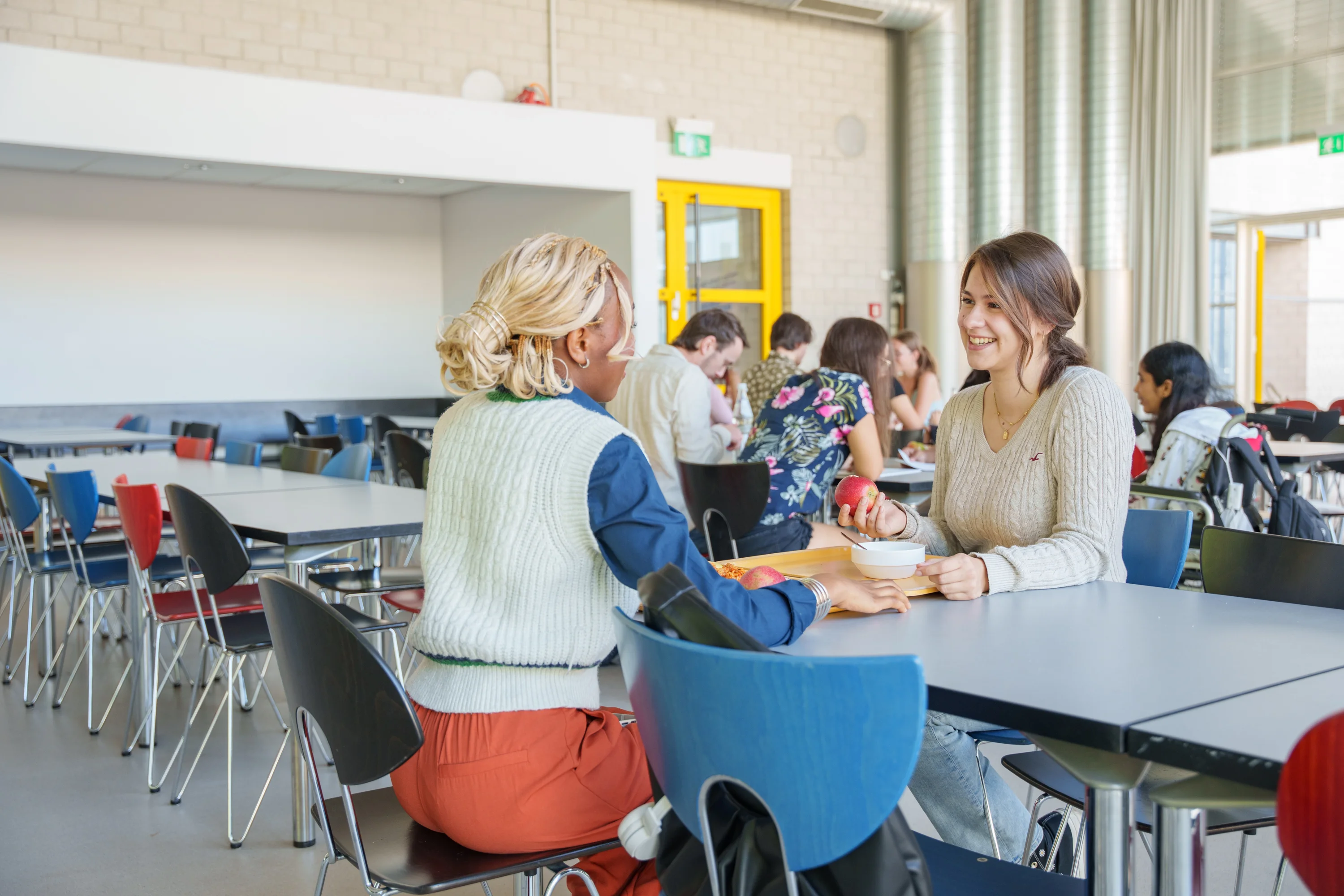 Zwei Studentinnen unterhalten sich beim Essen in der Mensa der TH Bingen.