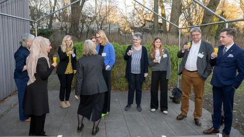 Menschen mit Sektgläsern im Gespräch auf der Terrasse
