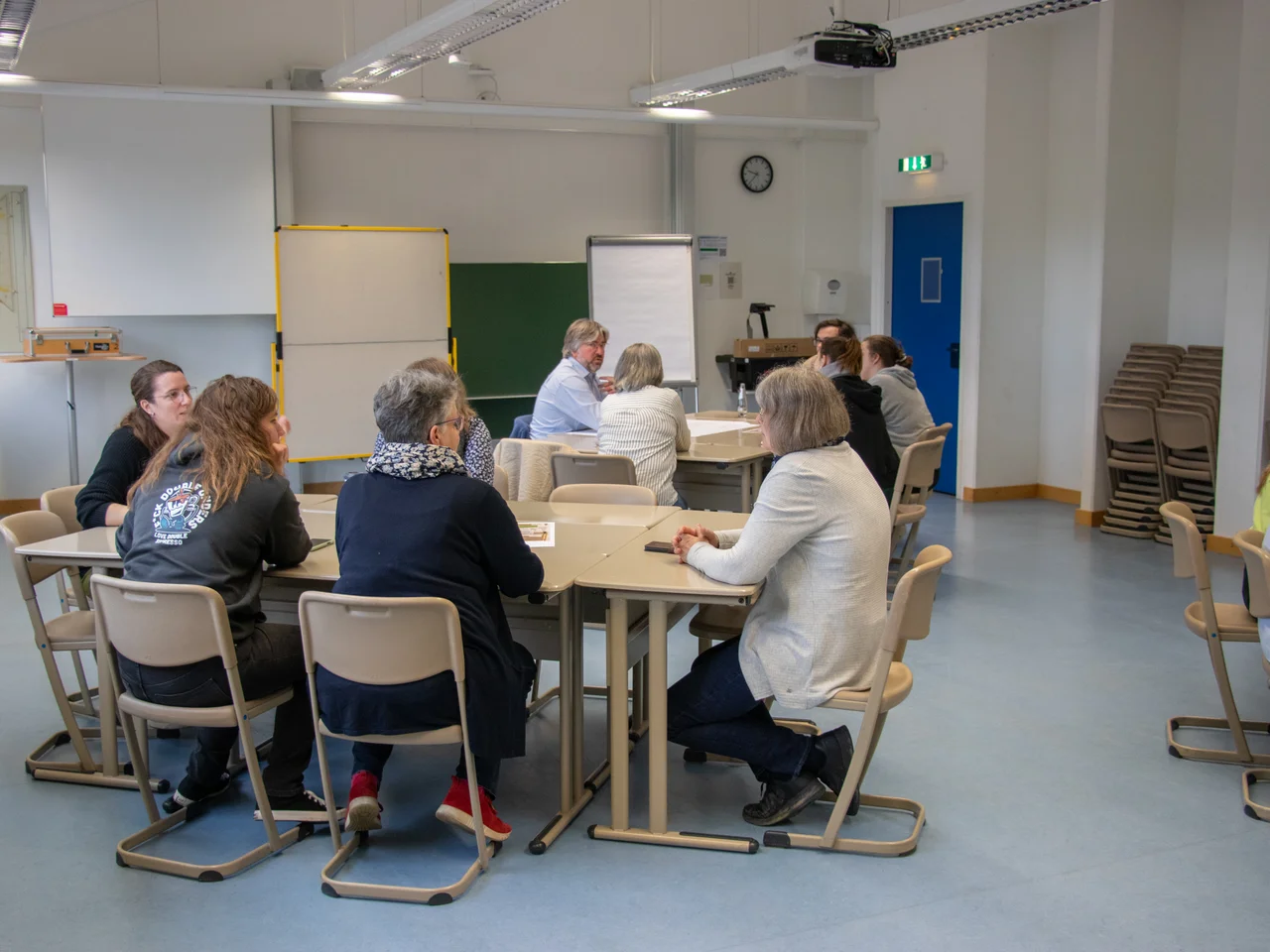 Eine Gruppe Personen diskutiert an einem Seminartisch.