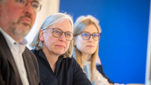 Unscharf vorne: Prof. Ganseuer, scharf Mitte: Prof. Krause, Frau unscharf im Hintergrund