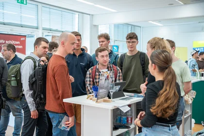 Studierende auf dem Industrietag 2025 im Beratungsgespräch am Stand.