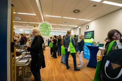 Bild vom Messeraum während der Umweltmesse 2026 an der TH Bingen mit Personen und Ständen im Hintergrund.