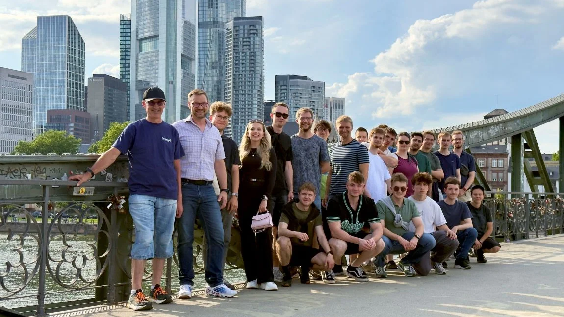 Gruppe Studierender auf einer Brücke vor der Frankfurter Skyline