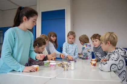 Das Bild zeigt eine Runde Kinder an einem Tisch während der Kinderhochschule.