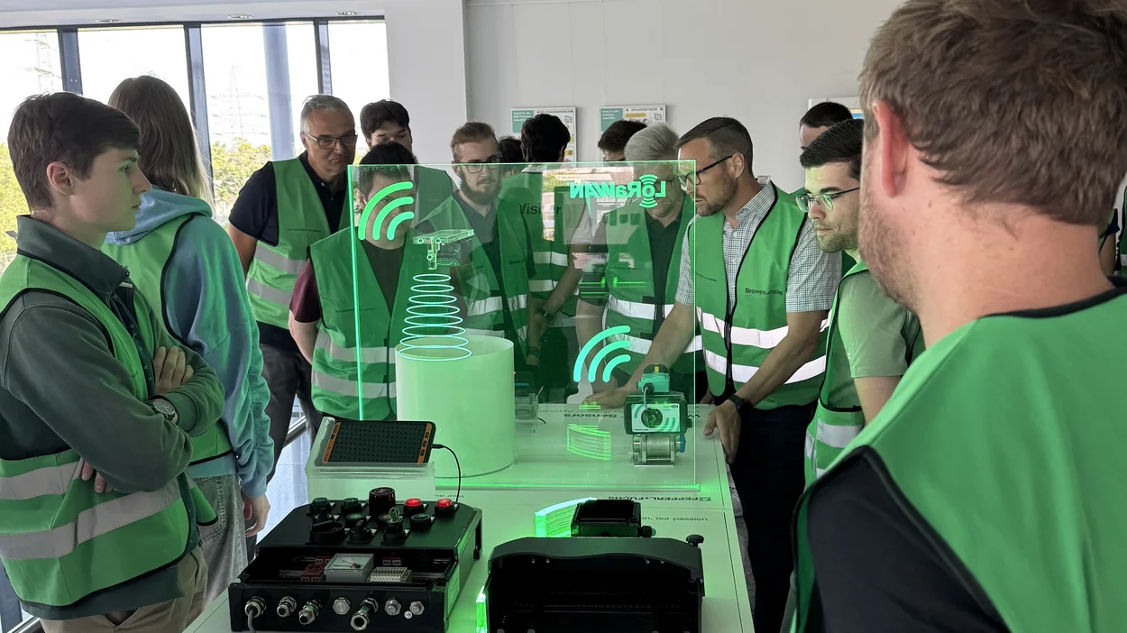 Studierende betrachten ein grün leuchtendes Objekt in der Mitte