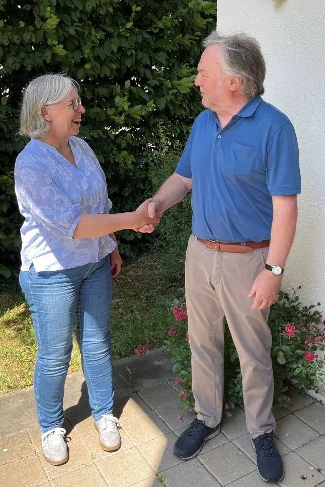 Prof. Dr. Antje Krause schüttelt Marcus Grünewald lachend die Hand