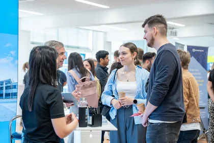 Studierende auf dem Industrietag 2025 im Beratungsgespräch am Stand.