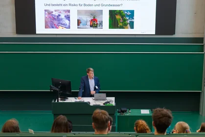 Ein Redner hält einen Vortrag in einem Vorlesungssaal