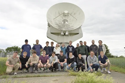Gruppe Studierender vor großer Satelittenschüssel