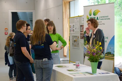 Eine kleine Gruppe von Leuten an einem Stand der Umweltmesse
