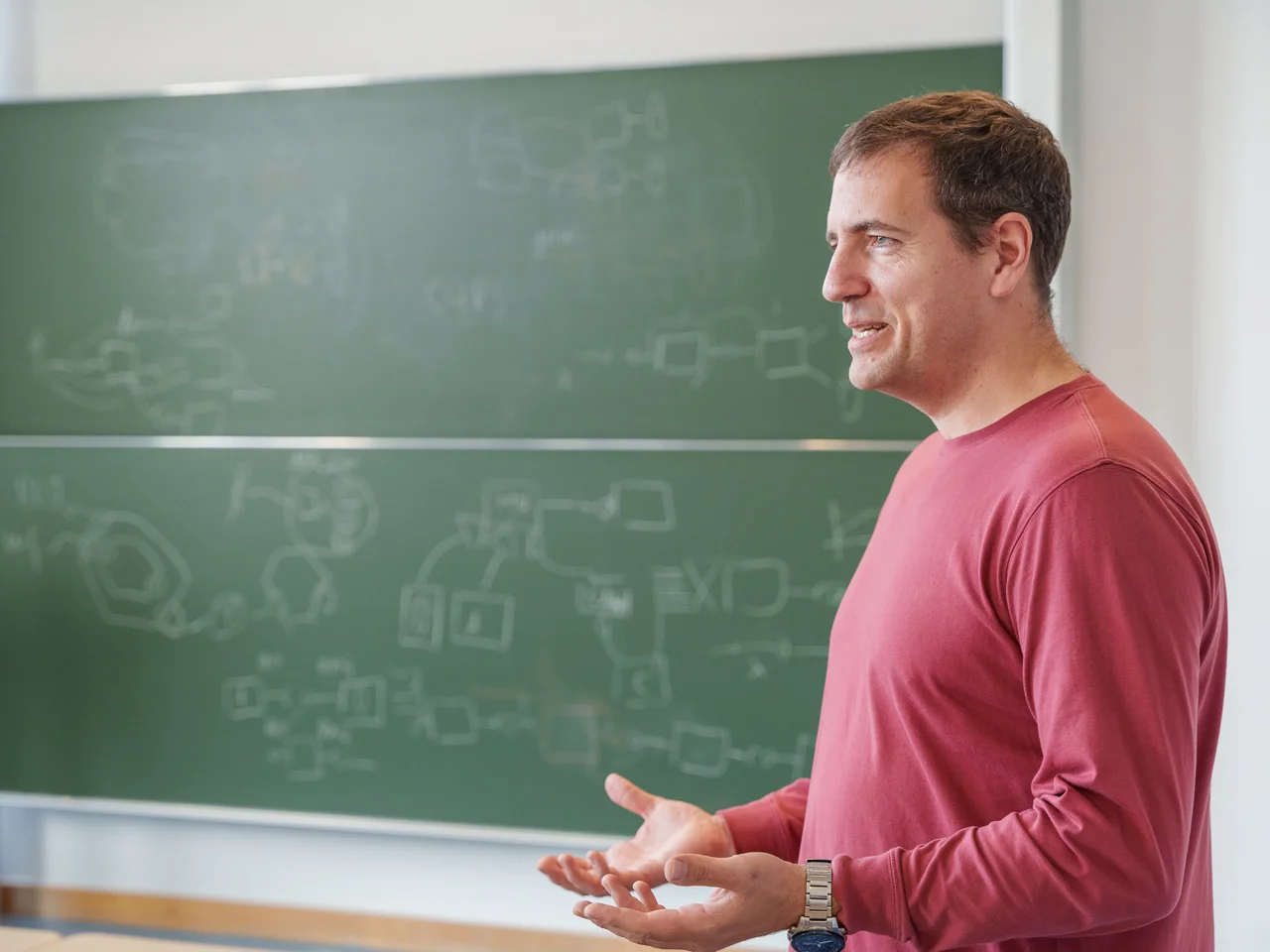 Ein Lehrbeauftragter der TH Bingen steht im Vorlesungssaal vor einer Tafel und unterrichtet.