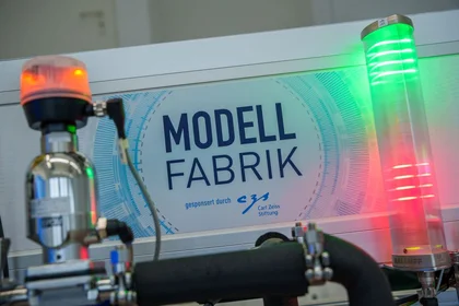 Schriftzug Modellfabrik mit roter und grüner leuchtender Lampe