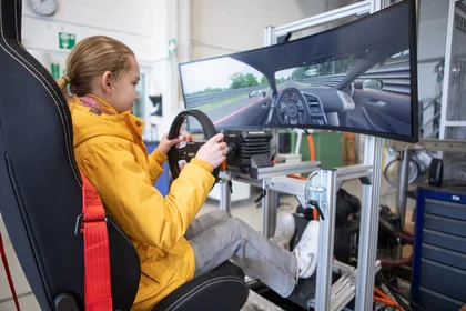 Eine Schülerin fährt einen Fahrsimulator