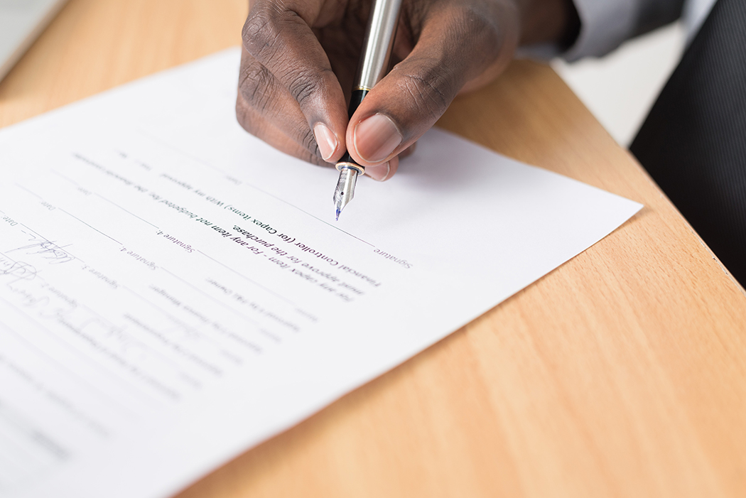 Hand signing a paper Hand signing a paper